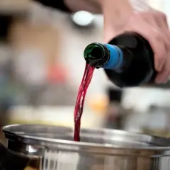 Rotwein wird in einen Topf gegossen. Beim Kochen verdunstet Alkohol.