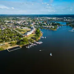 Malownicze miasto nad Jeziorakiem, z mariną pełną żaglówek i łodzi, otoczone zielenią i zabudową mieszkalną.