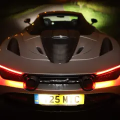 Tył srebrnego McLarena 720S nocą, z włączonymi czerwonymi światłami. Zastanawiasz się nad mclaren 720s cena?