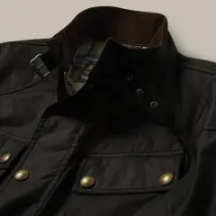 Chaqueta Belstaff negra, lista para limpiar en casa. Detalles de bolsillos, cremallera y logo dorado.