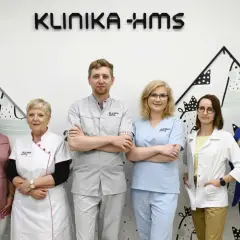 Zespół medyczny Kliniki HMS w Zielonej Górze: sześć osób w strojach medycznych i garniturze.