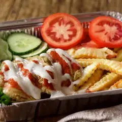 Pyszny kapsalon przepis z frytkami, mięsem, sałatą, pomidorem i ogórkiem, polany sosem.
