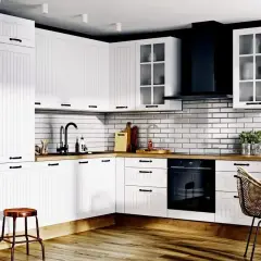 Biała kuchnia z czarnymi uchwytami. Listwa do szafek kuchennych znajduje się na wysokości ok. 140 cm od podłogi, nad blatem.