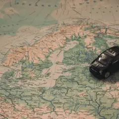Une petite voiture noire sur une carte d'Europe. Idéal pour une musique à mettre dans sa playlist de road trip.