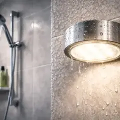 Wodoodporna lampa IP67 w łazience, oświetla wilgotne płytki, gdy prysznic jest włączony.