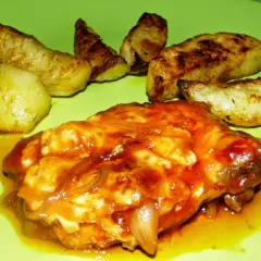 Karkówka pieczona w plastrach z majonezem i ketchupem, podana z pieczonymi ziemniakami. Pyszne danie na obiad.