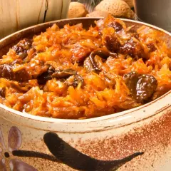 Pyszny bigos bez mięsa w glinianym naczyniu, pełen kapusty i grzybów.