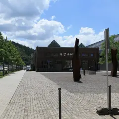 Die Halle 32 mit ihren markanten Glaspyramiden, umgeben von Bäumen und Skulpturen, an einem sonnigen Tag.