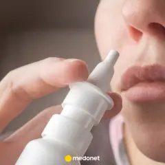 Dłoń trzymająca atomizer leku Avamys, gotowa do aplikacji do nosa.