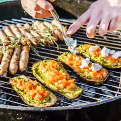 Kiełbaski i bakłażany z pesto i pomidorami pieką się na grillu. Idealne blachy na grilla na letnie popołudnie.