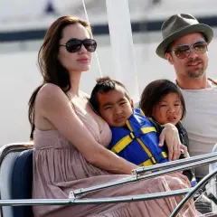 Angelina Jolie med sina barn på en båt. En av barnen bär en blå flytväst.