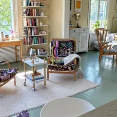 Ljust och inbjudande vardagsrum med bokhyllor, färgstarka fåtöljer och en soffgrupp. En harmonisk känsla av feng shui vardagsrum.