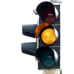 Un feu de circulation avec le voyant orange allumé. Le feu rouge est au-dessus, le vert en dessous.