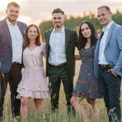 Uśmiechnięci uczestnicy "Rolnik szuka żony 10" pozują na tle złotego pola.