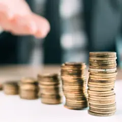 Stosy monet rosnące w górę, symbolizujące pomoc finansową, jak fundusz wsparcia kredytobiorców.