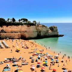 Playa con gente disfrutando del sol y el mar. Un día perfecto para actividades en el Algarve.