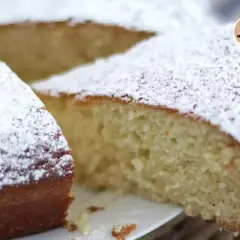 Una soffice torta allo yogurt, cosparsa di zucchero a velo, pronta per essere gustata.