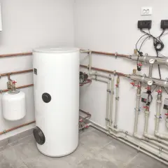 Instalacja grzewcza z kotłem na pellet i buforem. Widoczny bojler, naczynie przeponowe i rozdzielacz z pompami.
