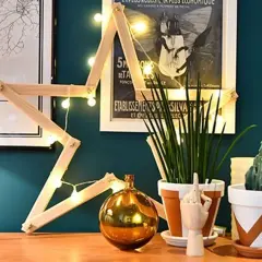 Étoile en bois faite maison, décorée de guirlandes lumineuses. Une décoration simple pour fabriquer une étoile en bois.