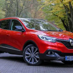 Czerwony Renault Kadjar na tle jesiennego lasu. Wady tego modelu to m.in. przeciętne wyciszenie i twarde zawieszenie.