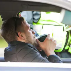 Mężczyzna dmucha w alkomat podczas kontroli drogowej. Sprawdzane są dopuszczalne promile w europie.