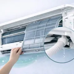 Mano retirando filtro de aire acondicionado. Se ve la manguera por donde sale el agua del aire acondicionado, goteando.
