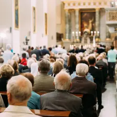 Ludzie siedzą w kościele, słuchając kazania. Czy msza w Wielką Sobotę jest obowiązkowa? To pytanie zadaje sobie wielu wiernych.