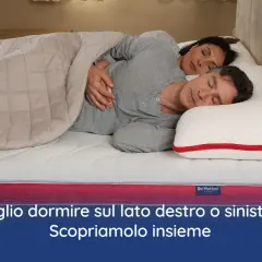 Coppia dorme abbracciata su un materasso. Meglio dormire sul lato destro o sinistro? Scopriamolo insieme.
