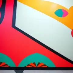 Żywe, geometryczne dzieła w stylu art déco z dominującymi czerwienią i żółcią, ozdobione czarnymi liniami i turkusowymi akcentami.