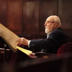 Krzysztof Penderecki w okularach, pochylony nad nutami. Ciekawe, co komponuje?