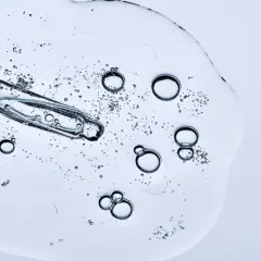 Kropla serum z pipetką, bąbelki. Czy peptydy można łączyć z witaminą C? To pytanie nurtuje wiele osób dbających o cerę.