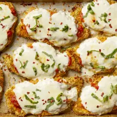 Cotolette di pollo impanate e gratinate con mozzarella filante, salsa di pomodoro e basilico fresco. Un elenco di cibi deliziosi pronti per essere gustati.