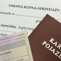 Umowa kupna-sprzedaży samochodu, karta pojazdu i pozwolenie czasowe. Dokumenty gotowe do sfinalizowania transakcji.