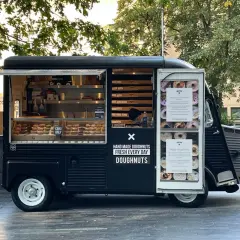 Food truck nero con ciambelle fatte a mano, fresche ogni giorno.