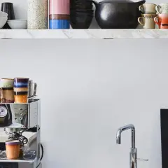 Stilvolle Kaffeebar Ideen: Chrom-Espressomaschine mit bunten Tassen, Marmorregal mit Geschirr und ein Stormtrooper-Dekor.