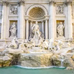 Fontana di Trevi: maestosa opera barocca con Nettuno al centro, cavalli marini e cascate d'acqua. Una descrizione iconica di Roma.