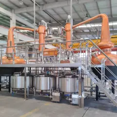 Nowoczesna instalacja do rektyfikacji z miedzianymi alembikami i stalowymi zbiornikami, gotowa do produkcji wysokiej jakości alkoholi.