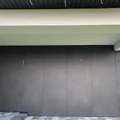 Nowoczesna elewacja z płyt spieku kwarcowego w ciemnoszarym kolorze, tworząca minimalistyczną i elegancką fasadę.