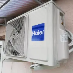 Jednostka zewnętrzna klimatyzatora Haier zamontowana na ścianie budynku.