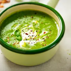Aksamitna zupa szpinakowa z kleksem śmietany i posypką z pieprzu i płatków chili. Idealna na chłodne dni.