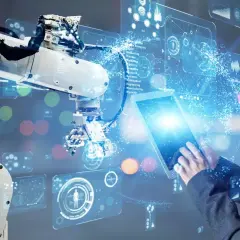 Inżynierka steruje robotem przemysłowym za pomocą tabletu, wizualizując dane w technologii **przemysł 5.0**.