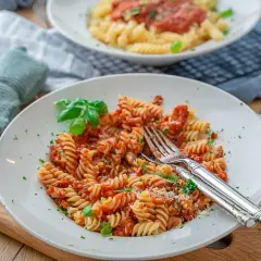 Eine köstliche Thunfisch Pasta mit Fusilli, Tomatensauce und frischem Basilikum, garniert mit Petersilie und Parmesan.