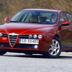 Czerwone Alfa Romeo 159 z kierowcą. Zastanawiasz się, jaki silnik ma to Alfa Romeo 159?