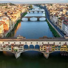 Mostra Ponte Vecchio, jeden z głównych punktów, które warto zobaczyć we Florencji, z kolorowymi budynkami i rzeką Arno.