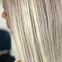 Cabello largo y liso con mechas rubias cenizas, luciendo un estilo moderno y elegante.