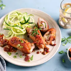 Herzhafte involtini vom Kalb mit Zucchini-Spaghetti und einer würzigen Tomatensauce, garniert mit Rosmarin.