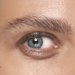 Ett blått öga med perfekt formade, fluffiga **soap brows**.
