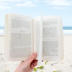 Otwarta książka na plaży, idealna lekka książka na wakacje.