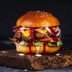 Soczysty burger wołowy z serem, cebulą i sosem. Idealny przykład, jak przyprawić mięso wołowe na burgery, by uzyskać wyśmienity smak.