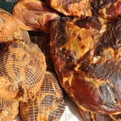 Gotowe do wędzenia mięso: wędzonki w siatkach i duże kawałki wędzonego mięsa. Idealne, by dowiedzieć się, jak przygotować mięso do wędzenia.